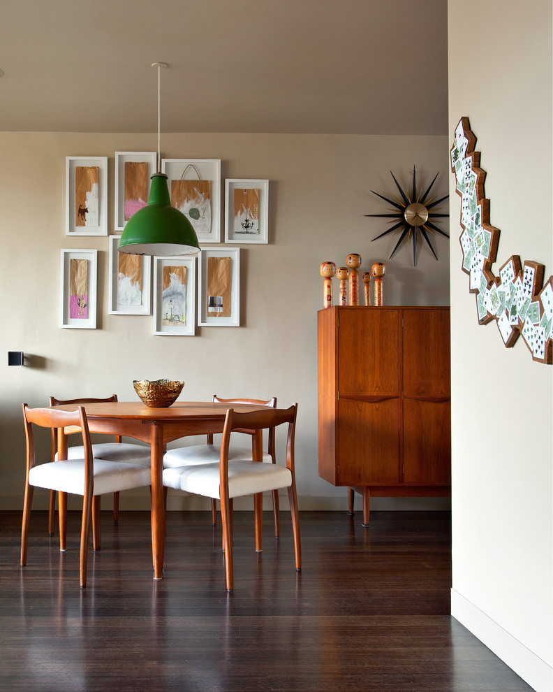 This is an example of a small midcentury dining room in Melbourne with beige walls and dark hardwood floors.