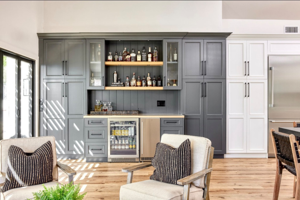 Transitional single-wall home bar with shaker cabinets, wood benchtops, brown benchtop, black cabinets, black splashback and shiplap splashback.