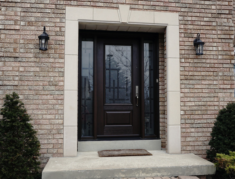 This is an example of a mid-sized transitional front door in Toronto with brown walls, a single front door and a dark wood front door.