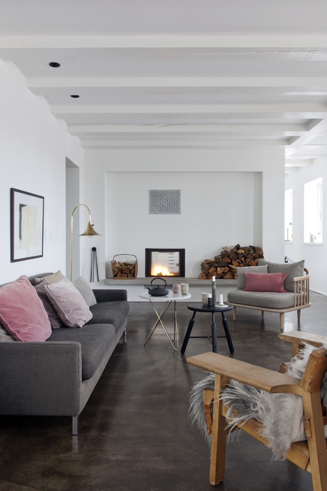This is an example of a large scandinavian formal open concept living room in Barcelona with white walls, concrete floors, a standard fireplace, no tv and brown floor.