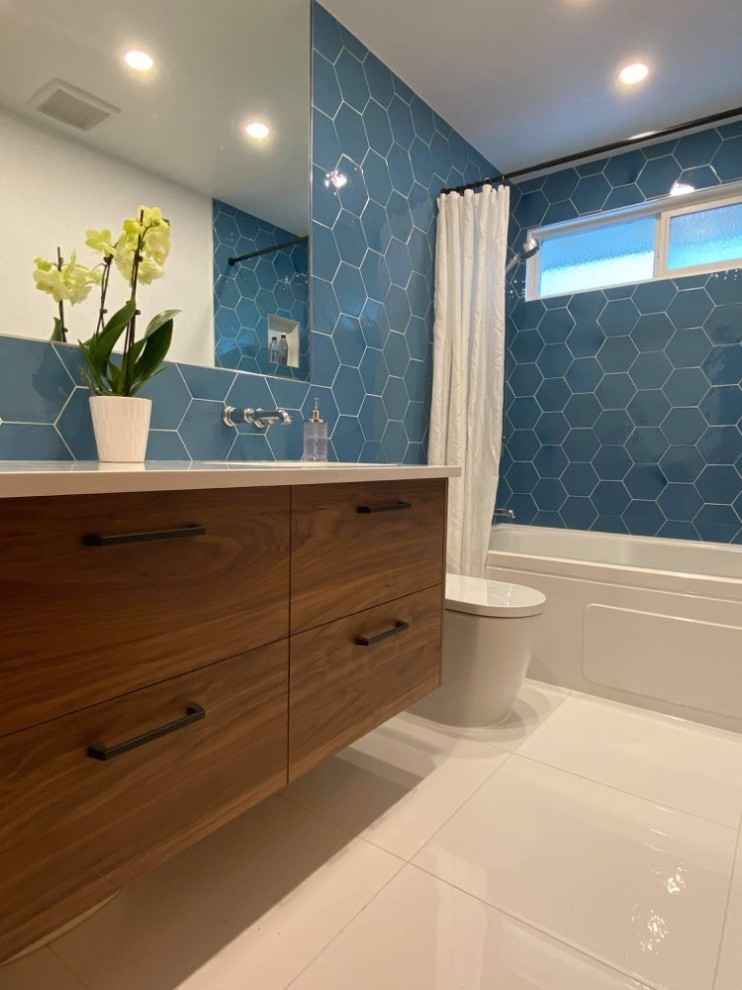 Источник вдохновения для домашнего уюта: ванная комната среднего размера в стиле модернизм с плоскими фасадами, темными деревянными фасадами, ванной в нише, душем над ванной, унитазом-моноблоком, синей плиткой, керамогранитной плиткой, белыми стенами, полом из керамогранита, монолитной раковиной, столешницей из искусственного кварца, белым полом, шторкой для ванной, белой столешницей, нишей, тумбой под одну раковину и подвесной тумбой