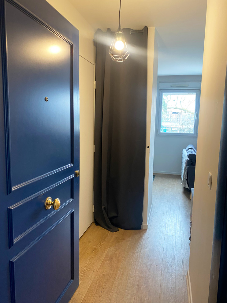 Ispirazione per una piccola porta d'ingresso nordica con pareti bianche, pavimento in laminato, una porta singola, una porta blu e pavimento marrone