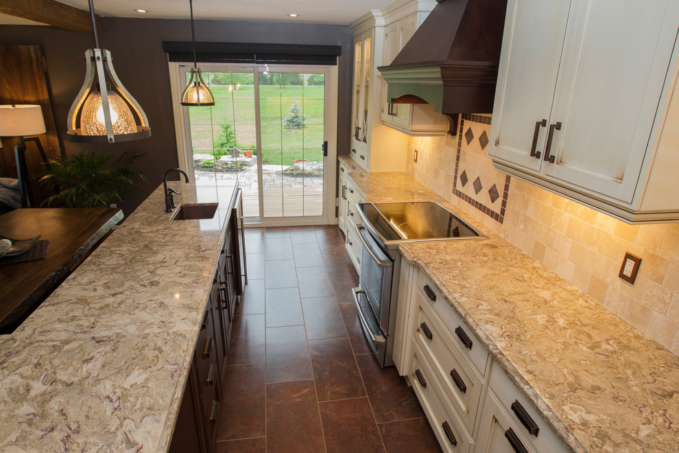 Photo of a large traditional l-shaped eat-in kitchen in Toronto with a farmhouse sink, recessed-panel cabinets, quartz benchtops, stainless steel appliances, terra-cotta floors and with island.