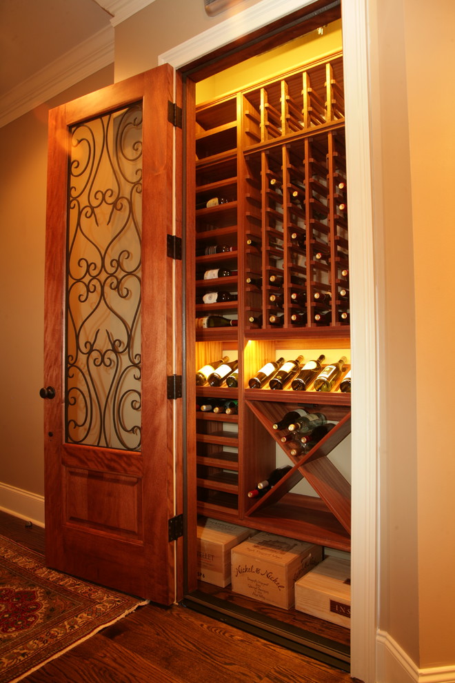 This is an example of a small traditional wine cellar in Charlotte with medium hardwood floors, storage racks and brown floor.