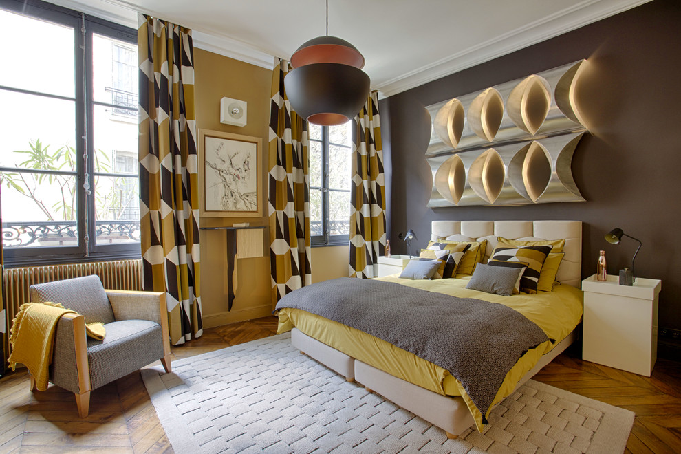 Exemple d'une grande chambre parentale rétro avec un mur jaune, parquet clair, aucune cheminée et un sol marron.