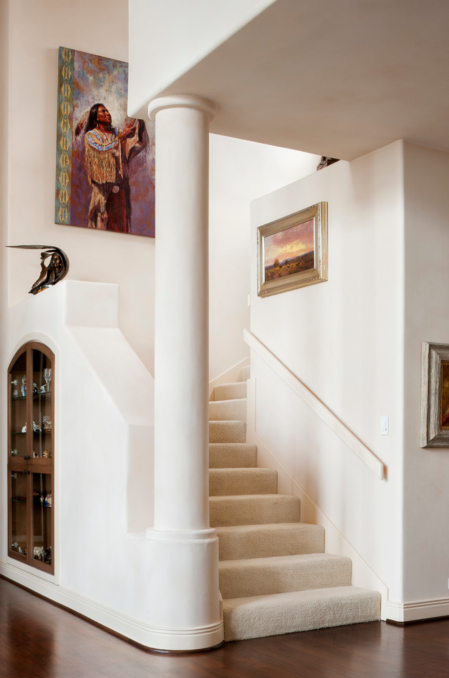 Photo of a mediterranean carpeted staircase in Austin with carpet risers.