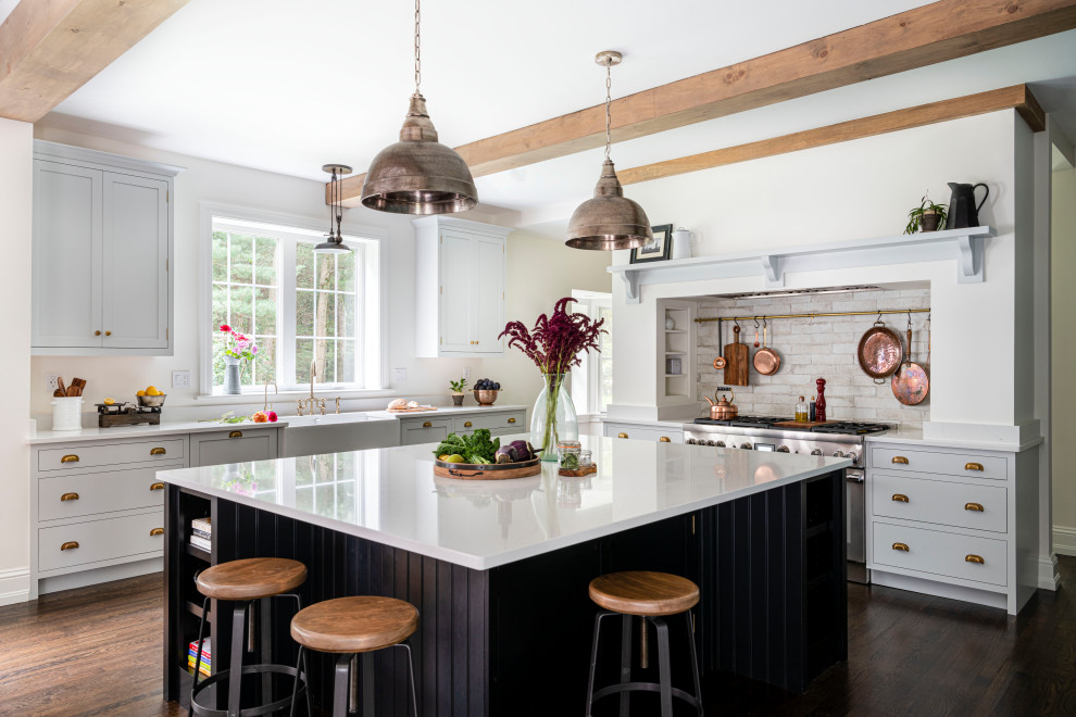 Eat-in kitchen - large farmhouse u-shaped dark wood floor, brown floor and exposed beam eat-in kitchen idea in Boston with a farmhouse sink, beaded inset cabinets, quartz countertops, multicolored backsplash, porcelain backsplash, stainless steel appliances, an island and white countertops