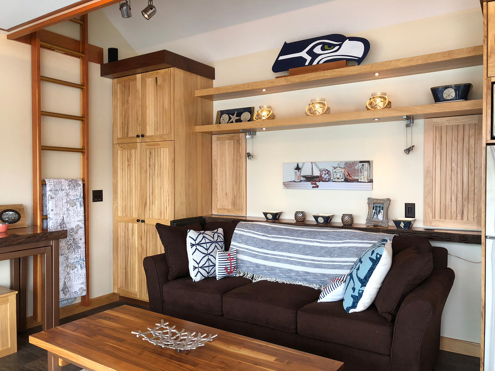 Design ideas for a small beach style enclosed family room in Seattle with a game room, beige walls, light hardwood floors, no fireplace, a wall-mounted tv and brown floor.