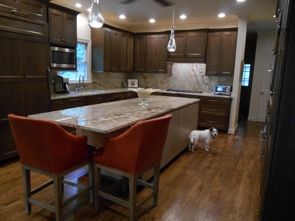 Eat-in kitchen - mid-sized transitional l-shaped medium tone wood floor eat-in kitchen idea in Birmingham with a single-bowl sink, flat-panel cabinets, medium tone wood cabinets, granite countertops, stone slab backsplash, paneled appliances, beige walls and an island