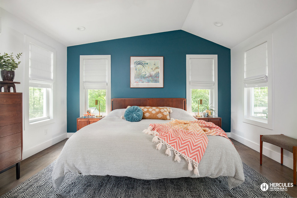 Cette photo montre une chambre parentale rétro de taille moyenne avec un mur bleu, un sol en bois brun, un sol gris et un plafond voûté.
