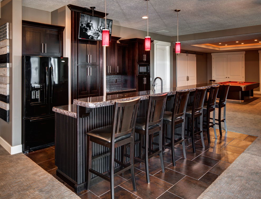 Design ideas for a mid-sized traditional single-wall seated home bar in Salt Lake City with an undermount sink, shaker cabinets, dark wood cabinets, granite benchtops, grey splashback, stone tile splashback, porcelain floors and brown floor.