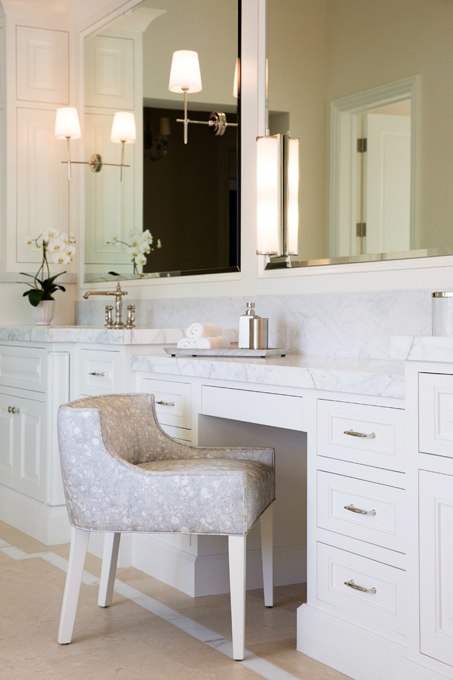 Photo of a large transitional master bathroom in San Diego with beaded inset cabinets, white cabinets, a curbless shower, a one-piece toilet, beige tile, limestone, beige walls, limestone floors, an undermount sink, marble benchtops and brown floor.