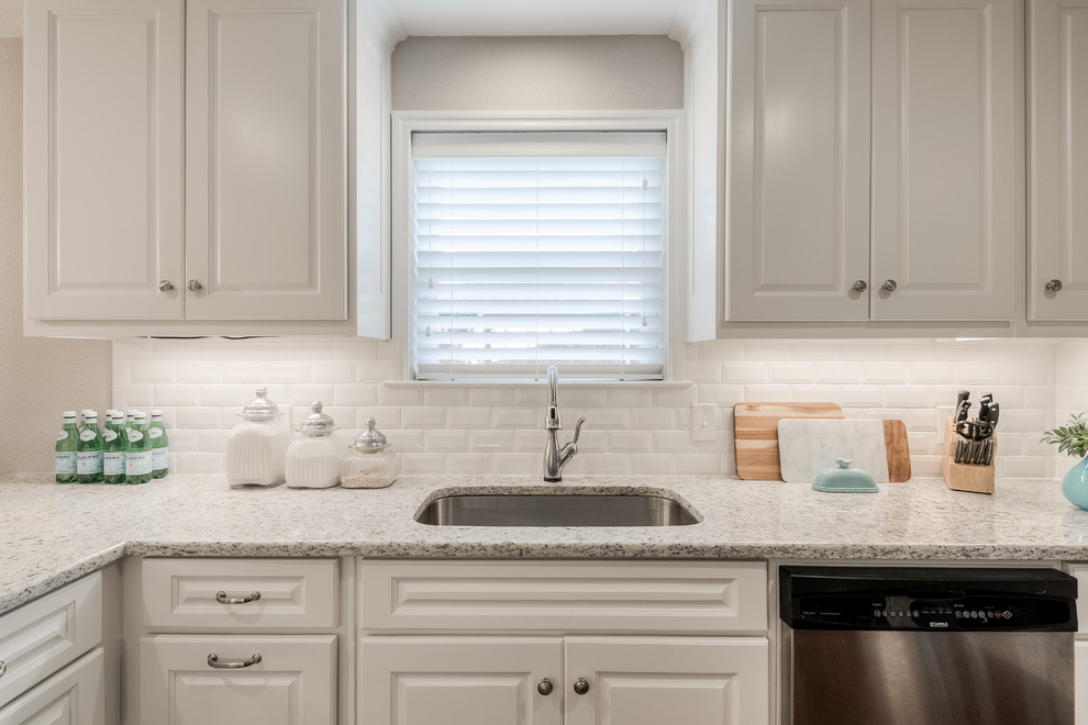Enclosed kitchen - mid-sized transitional galley medium tone wood floor enclosed kitchen idea in Dallas with an undermount sink, raised-panel cabinets, white cabinets, granite countertops, white backsplash, subway tile backsplash, stainless steel appliances and a peninsula