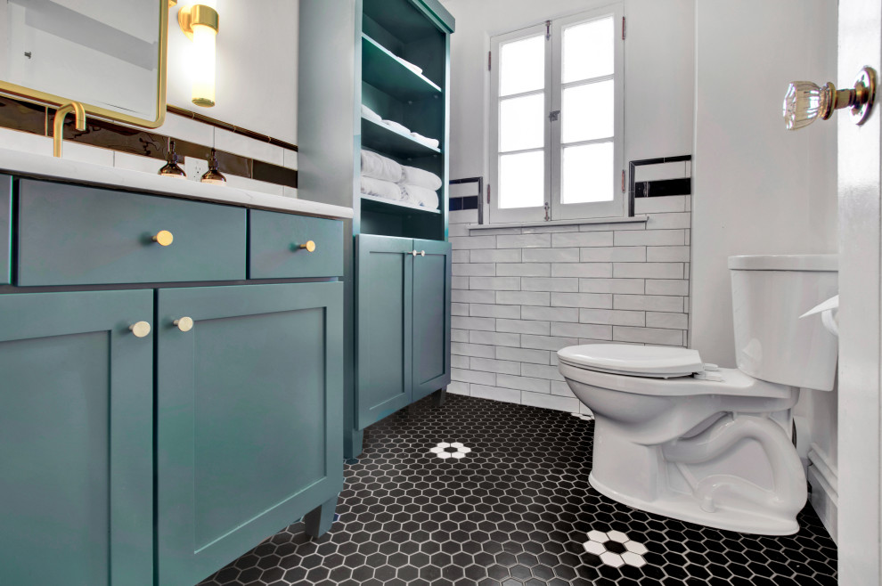 Example of a mid-sized transitional master black and white tile mosaic tile floor, multicolored floor and single-sink alcove shower design in St Louis with green cabinets, a one-piece toilet, white walls, a hinged shower door and a built-in vanity