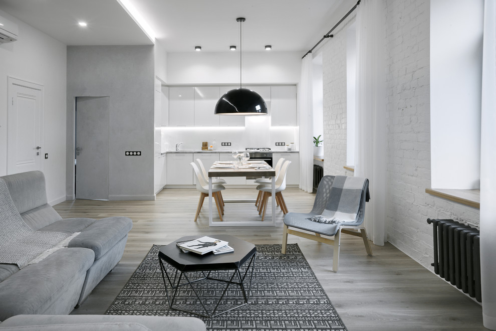 This is an example of a scandinavian open concept living room in Saint Petersburg with white walls, medium hardwood floors and grey floor.