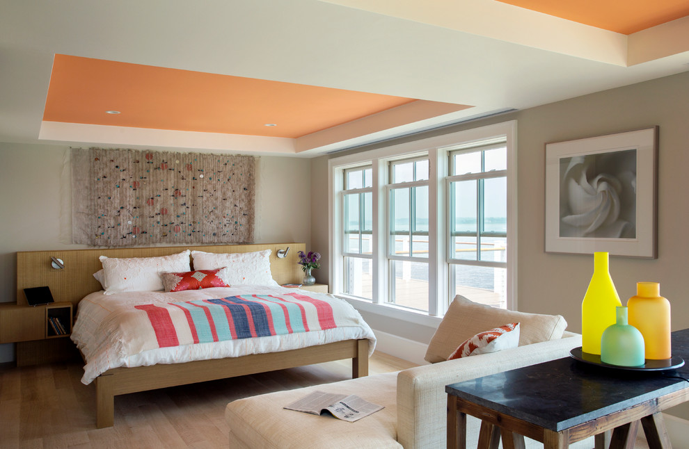 Beach style master bedroom in Providence with beige walls and light hardwood floors.