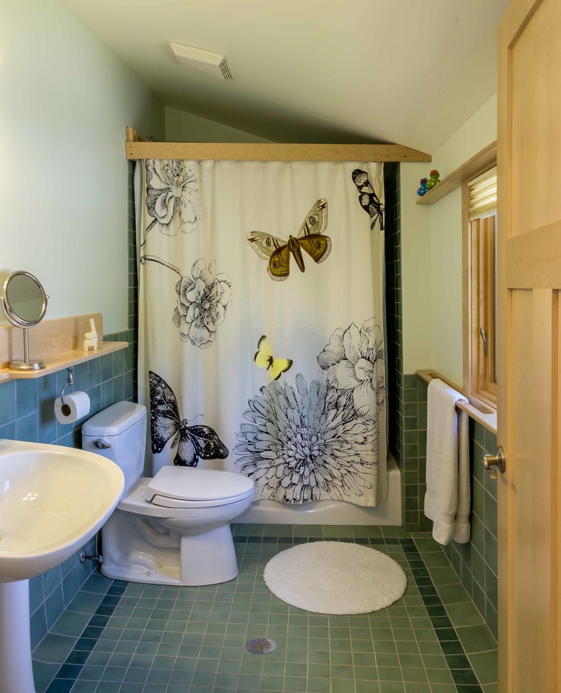 This is an example of a mid-sized eclectic master bathroom in Chicago with an alcove tub, a shower/bathtub combo, a one-piece toilet, green tile, glass tile, white walls, ceramic floors, a pedestal sink, green floor, a shower curtain, shaker cabinets, light wood cabinets, wood benchtops, brown benchtops, a single vanity, a floating vanity, vaulted and wallpaper.