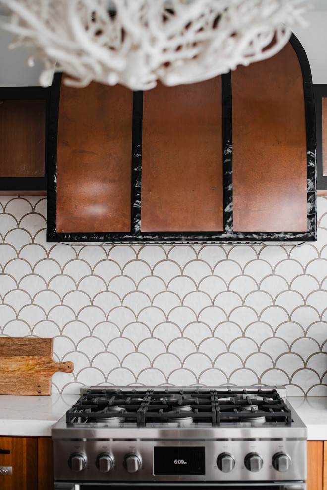 Kitchen - transitional kitchen idea with a farmhouse sink, flat-panel cabinets, medium tone wood cabinets, white backsplash, stainless steel appliances, an island and white countertops