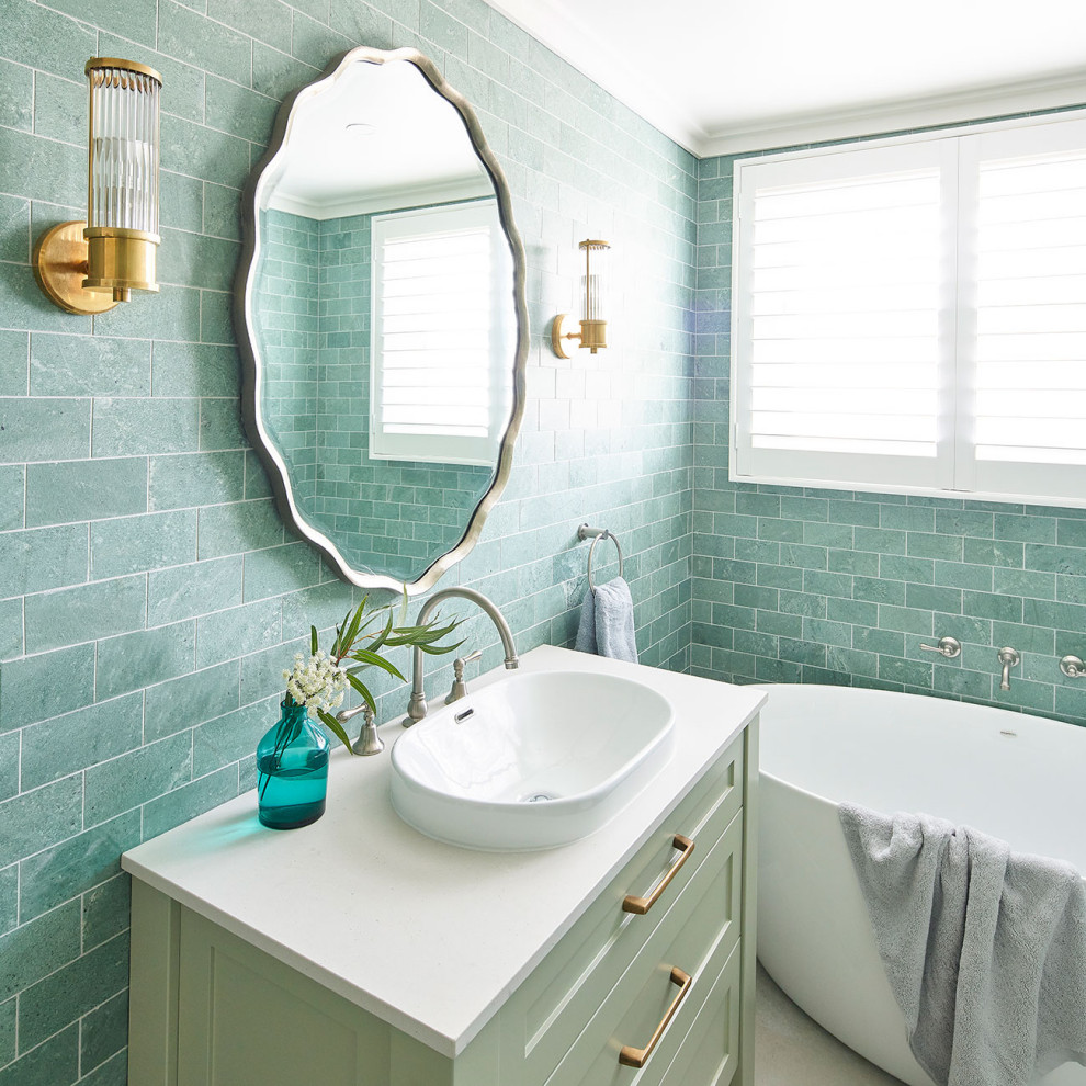 Mid-sized beach style master bathroom in Central Coast with recessed-panel cabinets, green cabinets, a freestanding tub, blue tile, blue walls, a drop-in sink, marble benchtops, white benchtops, a single vanity and a built-in vanity.