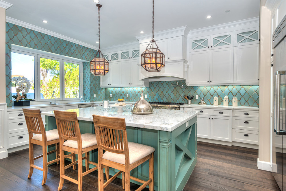 This is an example of a large traditional l-shaped kitchen in Los Angeles with white cabinets, marble benchtops, cement tile splashback, stainless steel appliances, with island, brown floor, shaker cabinets, dark hardwood floors and blue splashback.