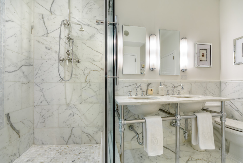 Inspiration for a mid-sized contemporary master bathroom in New York with an undermount sink, marble benchtops, an alcove shower, a one-piece toilet, white tile, stone tile, white walls and marble floors.