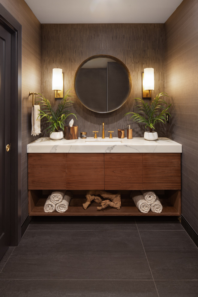 This is an example of a mid-sized contemporary bathroom in Kansas City with flat-panel cabinets, medium wood cabinets, an open shower, gray tile, cement tile, quartzite benchtops, white benchtops, a single vanity, a floating vanity, a one-piece toilet, grey walls, ceramic floors, an undermount sink, grey floor, an open shower and wallpaper.