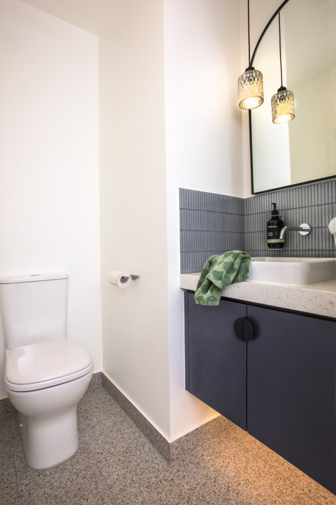 Inspiration for a small mid-century modern blue tile and matchstick tile terrazzo floor and gray floor powder room remodel in Melbourne with a two-piece toilet, a drop-in sink, quartz countertops and a floating vanity
