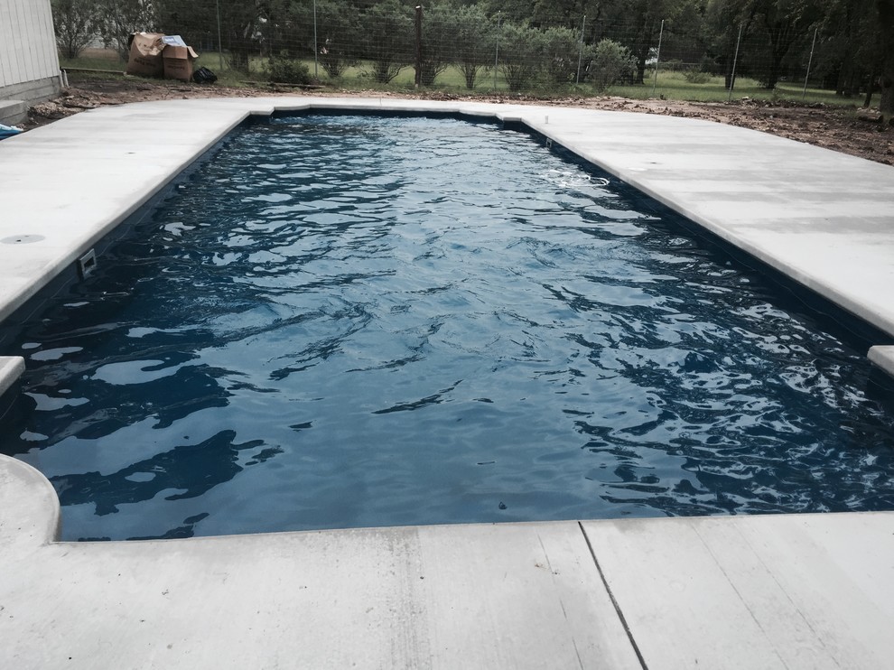 Large indoor concrete and custom-shaped indoor pool photo in Austin