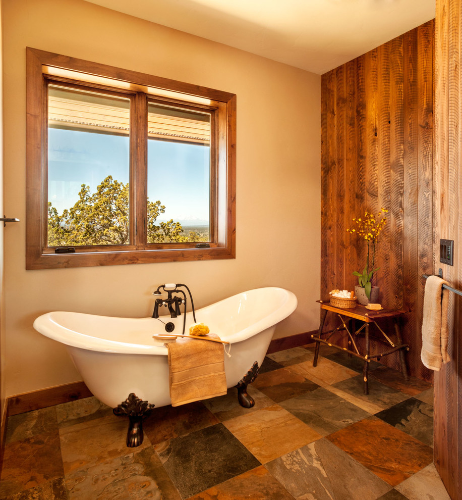 This is an example of a large country master bathroom in Other with recessed-panel cabinets, dark wood cabinets, a claw-foot tub, an alcove shower, gray tile, porcelain tile, beige walls, slate floors, an undermount sink, granite benchtops, brown floor, a hinged shower door and grey benchtops.