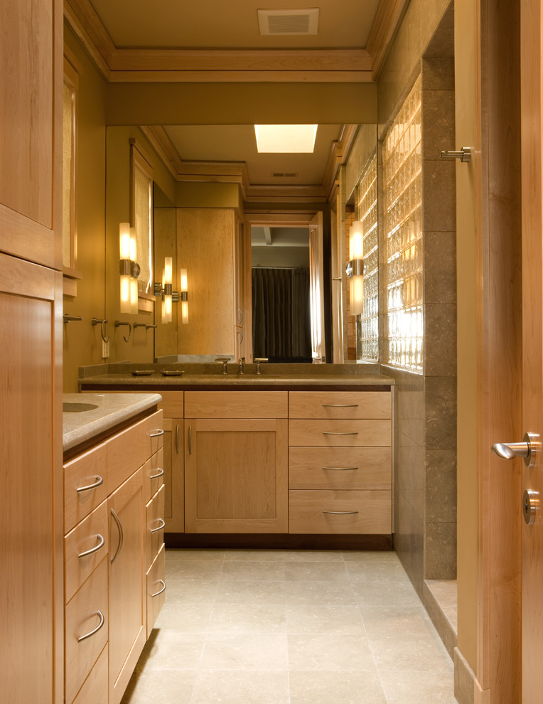 Photo of a contemporary bathroom in Atlanta with light wood cabinets and beige tile.