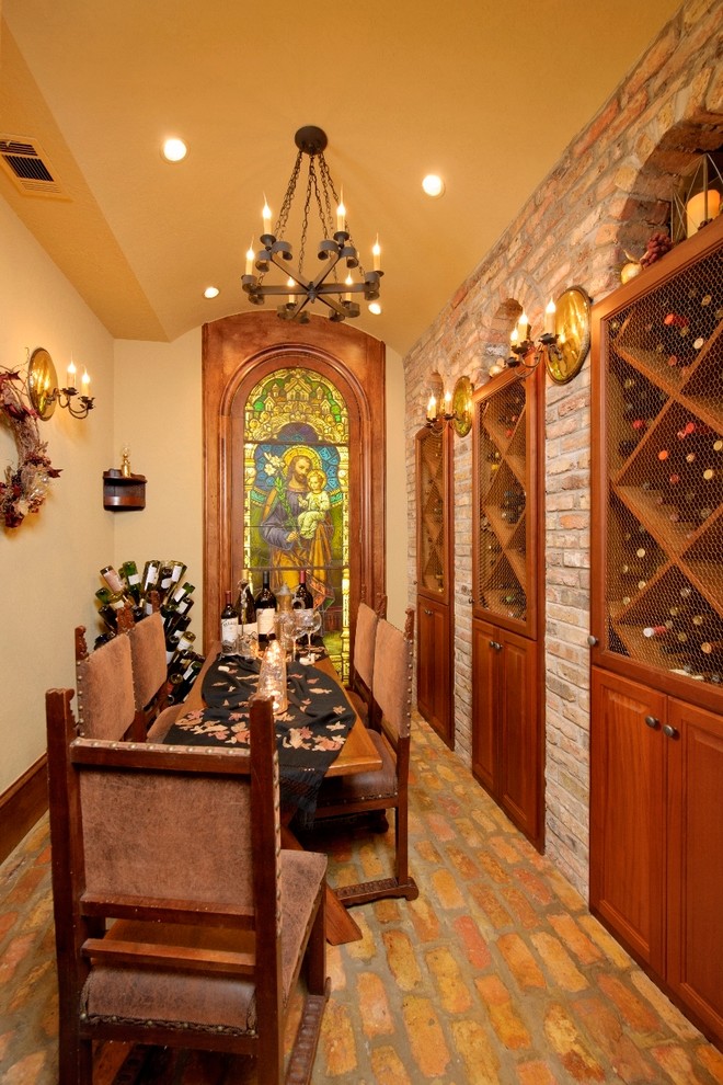 This is an example of a mediterranean wine cellar in Houston with brick floors and yellow floor.