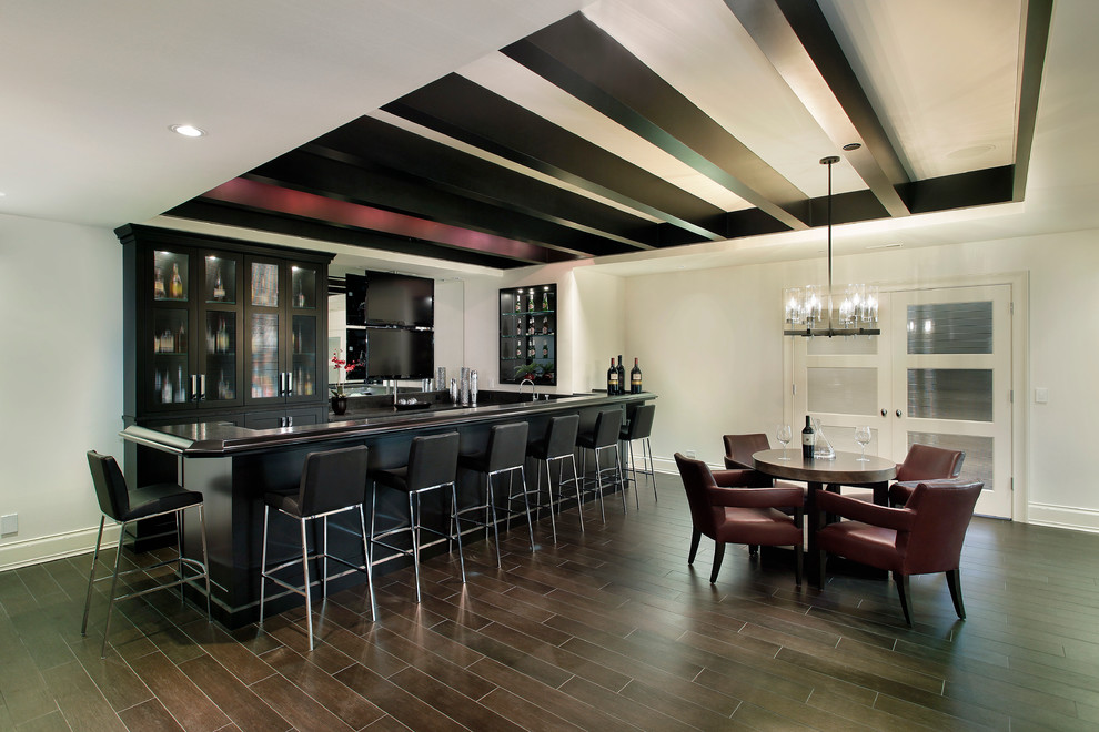 Design ideas for a large transitional basement in Chicago with white walls, dark hardwood floors, brown floor and a home bar.