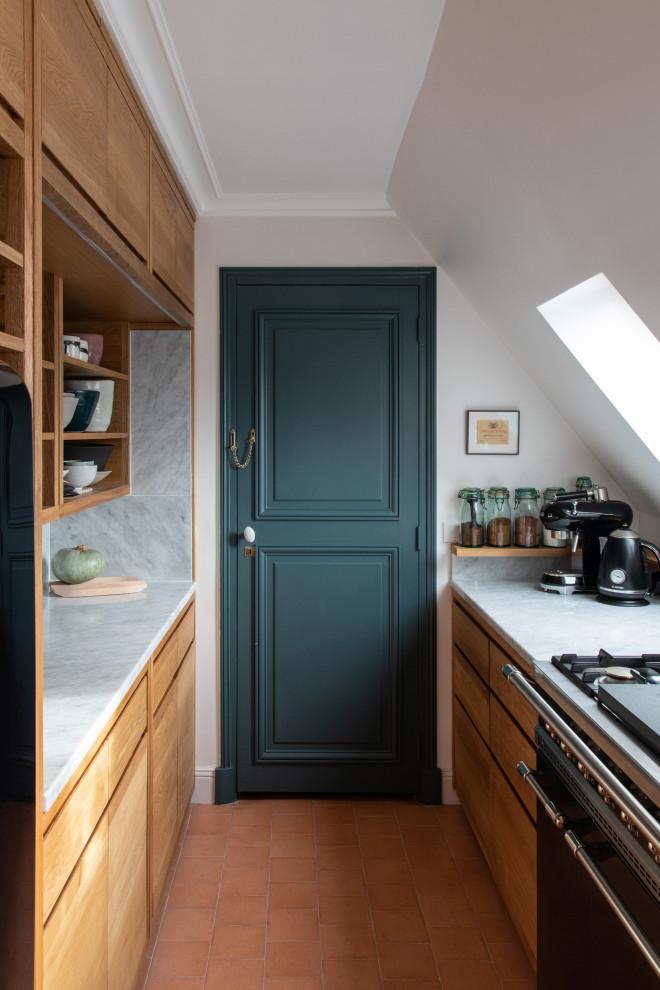 This is an example of a small contemporary galley separate kitchen in Paris with flat-panel cabinets, medium wood cabinets, grey splashback, black appliances, terra-cotta floors, no island, orange floor and grey benchtop.