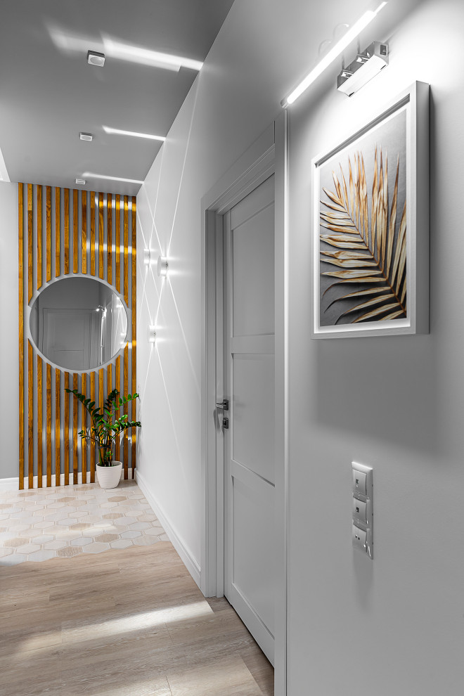На фото: коридор среднего размера: освещение в стиле неоклассика (современная классика) с белыми стенами, полом из винила, бежевым полом, любым потолком и любой отделкой стен