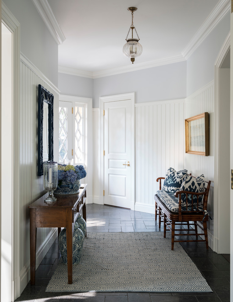 Photo of a large traditional hallway in New York with blue walls and grey floor.