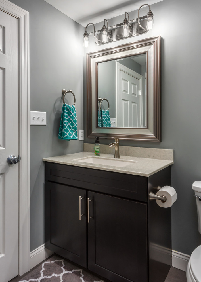 Small transitional 3/4 bathroom in St Louis with shaker cabinets, dark wood cabinets, an open shower, a two-piece toilet, gray tile, porcelain tile, grey walls, porcelain floors, an integrated sink, onyx benchtops, grey floor and an open shower.