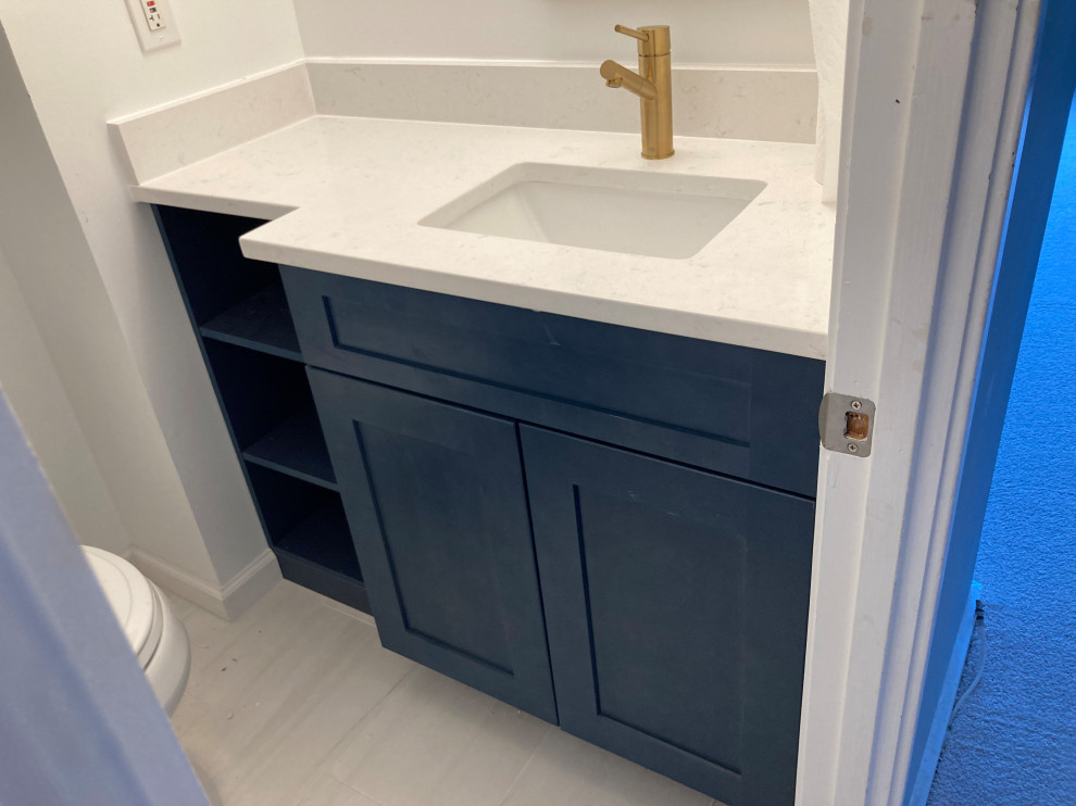 Design ideas for a small modern 3/4 bathroom in DC Metro with shaker cabinets, blue cabinets, an alcove shower, a two-piece toilet, white tile, porcelain tile, white walls, porcelain floors, an undermount sink, quartzite benchtops, white floor, a shower curtain, white benchtops, a single vanity and a built-in vanity.