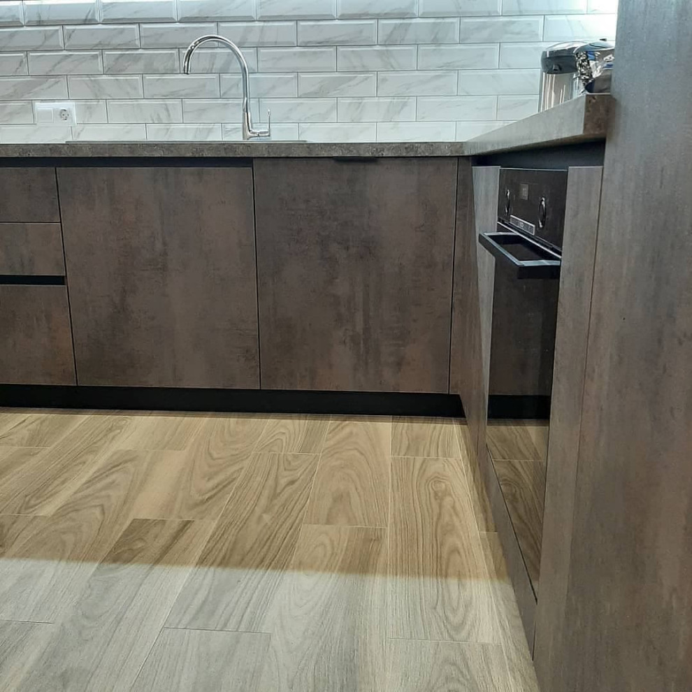 Large modern u-shaped eat-in kitchen in Moscow with a drop-in sink, recessed-panel cabinets, brown cabinets, solid surface benchtops, grey splashback, mosaic tile splashback, black appliances, medium hardwood floors, multiple islands, brown floor and grey benchtop.