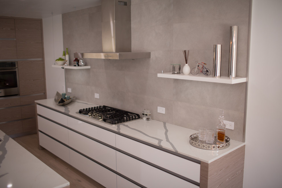 This is an example of a mid-sized modern single-wall open plan kitchen in Seattle with a double-bowl sink, open cabinets, white cabinets, quartzite benchtops, grey splashback, marble splashback, stainless steel appliances, bamboo floors, with island and brown floor.