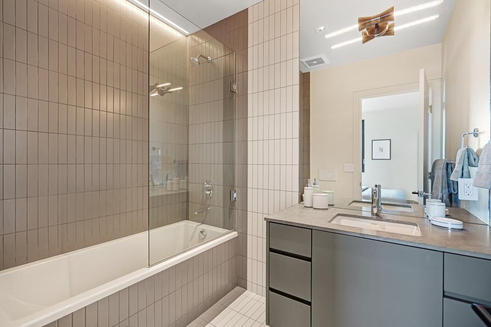Inspiration for a mid-sized contemporary bathroom in San Francisco with flat-panel cabinets, grey cabinets, a drop-in tub, a shower/bathtub combo, beige tile, ceramic tile, white walls, ceramic floors, a drop-in sink, beige floor and a hinged shower door.