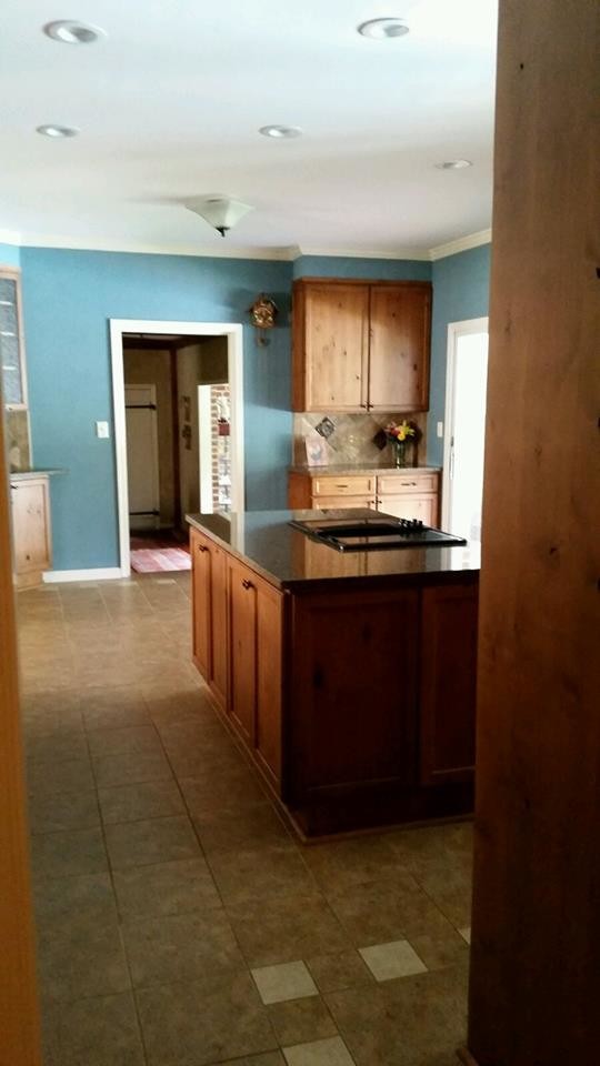 Eat-in kitchen - mid-sized transitional l-shaped ceramic tile and brown floor eat-in kitchen idea in Baltimore with a farmhouse sink, flat-panel cabinets, medium tone wood cabinets, granite countertops, gray backsplash, ceramic backsplash, paneled appliances and an island