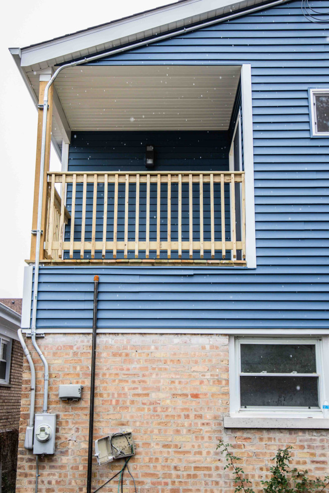 Inspiration pour une façade de maison bleue minimaliste à un étage avec un revêtement mixte et un toit noir.