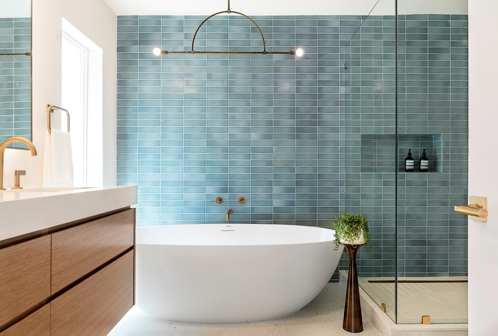 Inspiration for a contemporary master bathroom in Los Angeles with flat-panel cabinets, medium wood cabinets, a freestanding tub, blue tile, gray tile, white walls, an undermount sink, beige floor, a hinged shower door, white benchtops, a single vanity and a floating vanity.