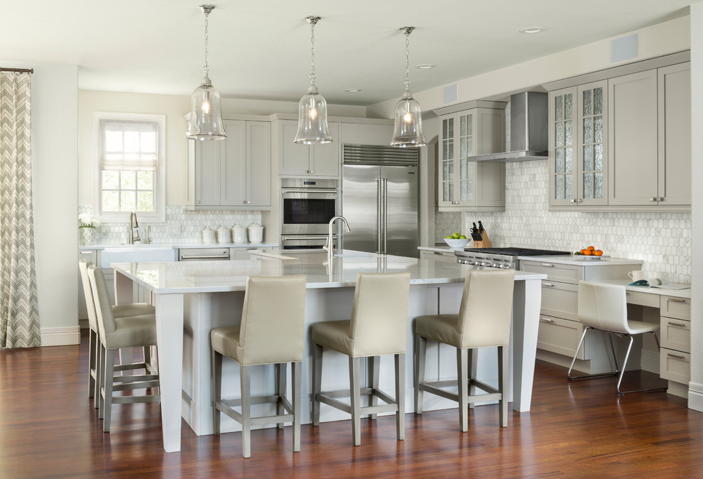Design ideas for a transitional kitchen in Denver with shaker cabinets, grey cabinets, stainless steel appliances, medium hardwood floors, with island and white benchtop.