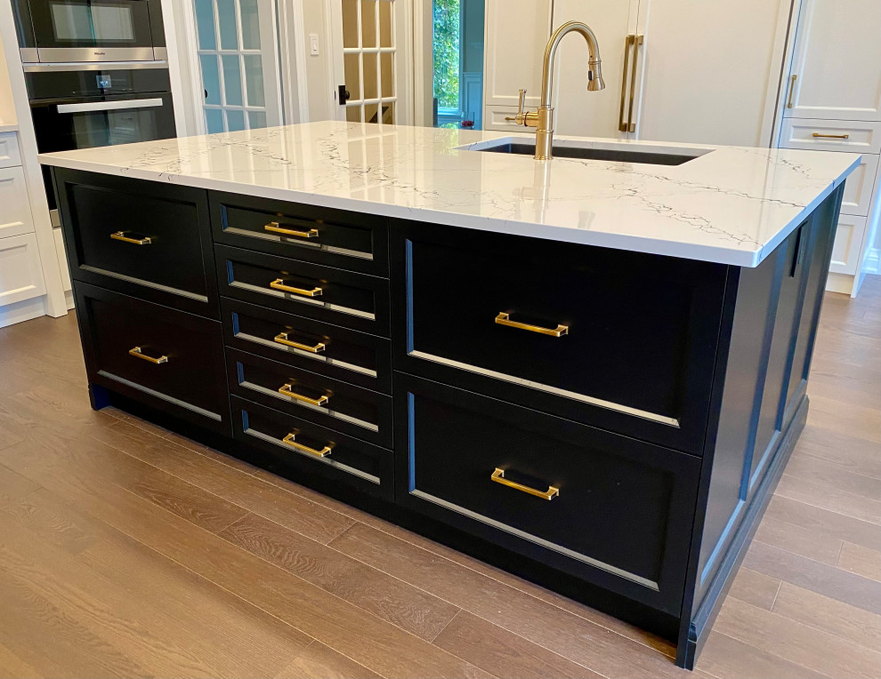 Example of a large transitional medium tone wood floor kitchen design in Toronto with an undermount sink, recessed-panel cabinets, white cabinets, quartz countertops, white backsplash, porcelain backsplash, paneled appliances, two islands and white countertops