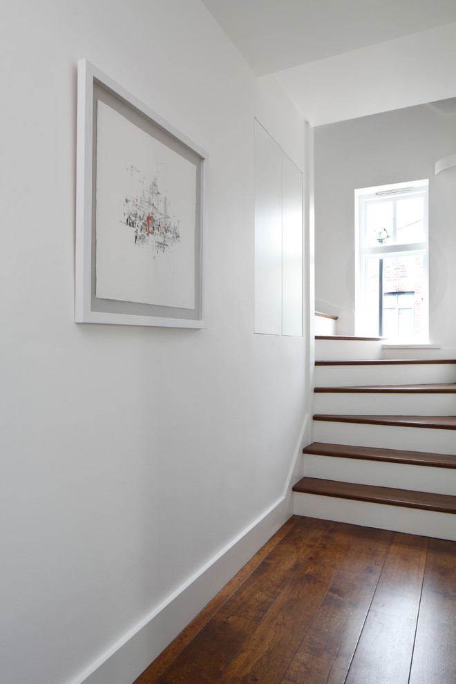 Design ideas for a small contemporary hallway in London with white walls, dark hardwood floors and brown floor.