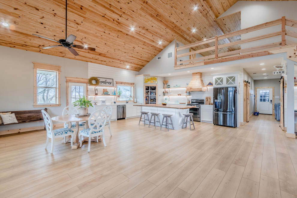 Idées déco pour une salle à manger ouverte sur le salon campagne de taille moyenne avec un mur blanc, un sol en vinyl, un sol beige, un plafond en bois et du lambris de bois.
