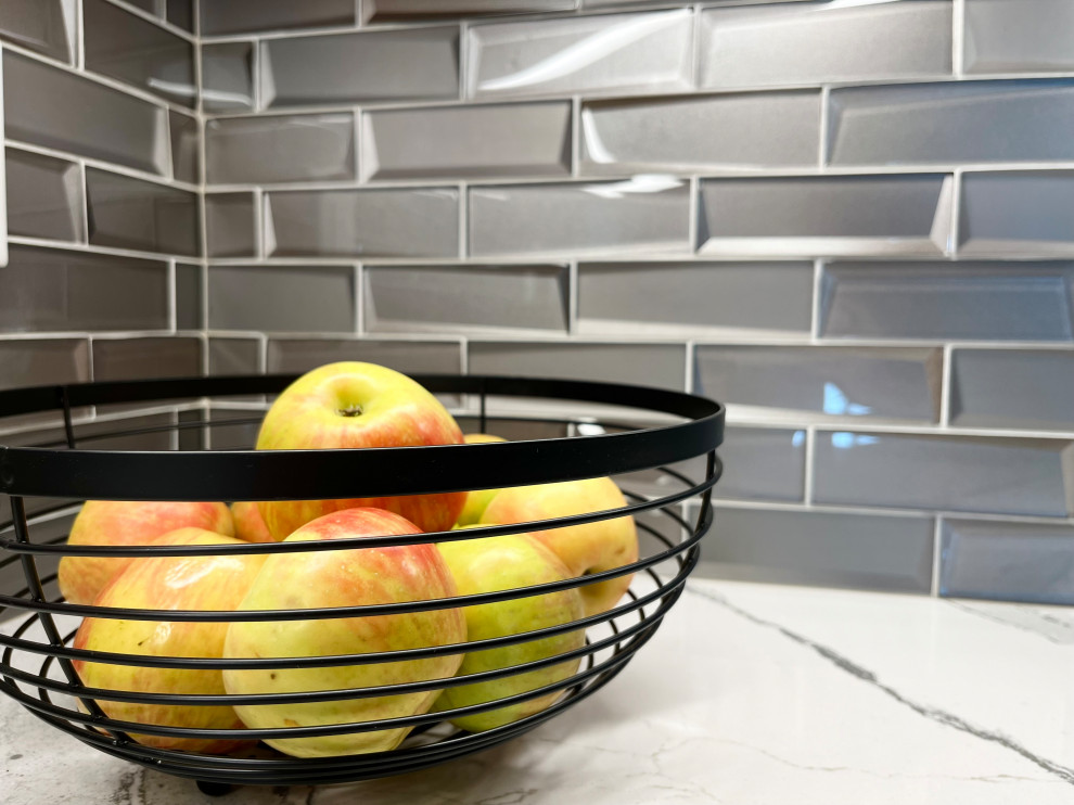 Inspiration for a mid-sized transitional l-shaped dark wood floor and brown floor eat-in kitchen remodel with an undermount sink, gray cabinets, quartz countertops, glass tile backsplash, stainless steel appliances, an island, white backsplash and beige countertops