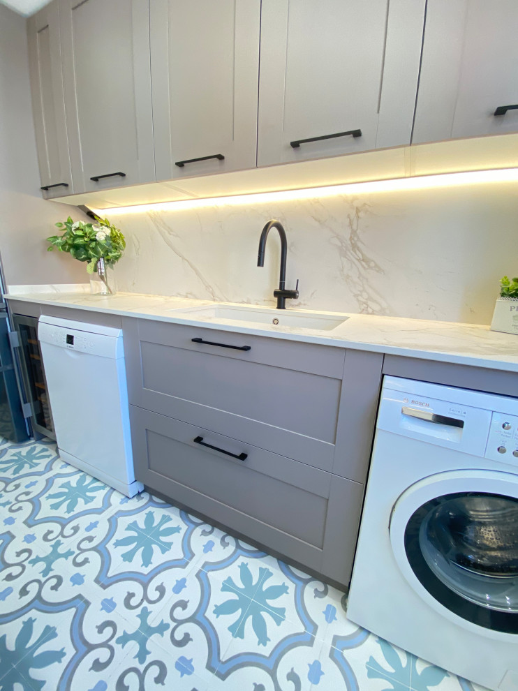 Idéer för en stor klassisk vita u-formad tvättstuga, med en undermonterad diskho, luckor med profilerade fronter, marmorbänkskiva, vitt stänkskydd, stänkskydd i marmor, klinkergolv i porslin och flerfärgat golv
