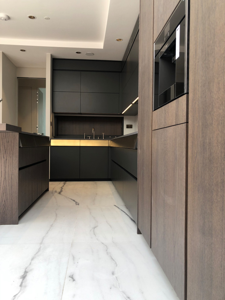 Photo of a large modern grey and brown u-shaped kitchen/diner in London with a built-in sink, flat-panel cabinets, dark wood cabinets, concrete worktops, white splashback, glass sheet splashback, black appliances, ceramic flooring, an island, white floors, grey worktops, a drop ceiling and a feature wall.